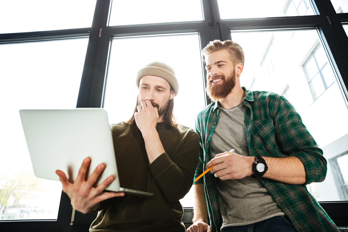 young-concentrated-men-colleagues-office-using-laptop.jpg